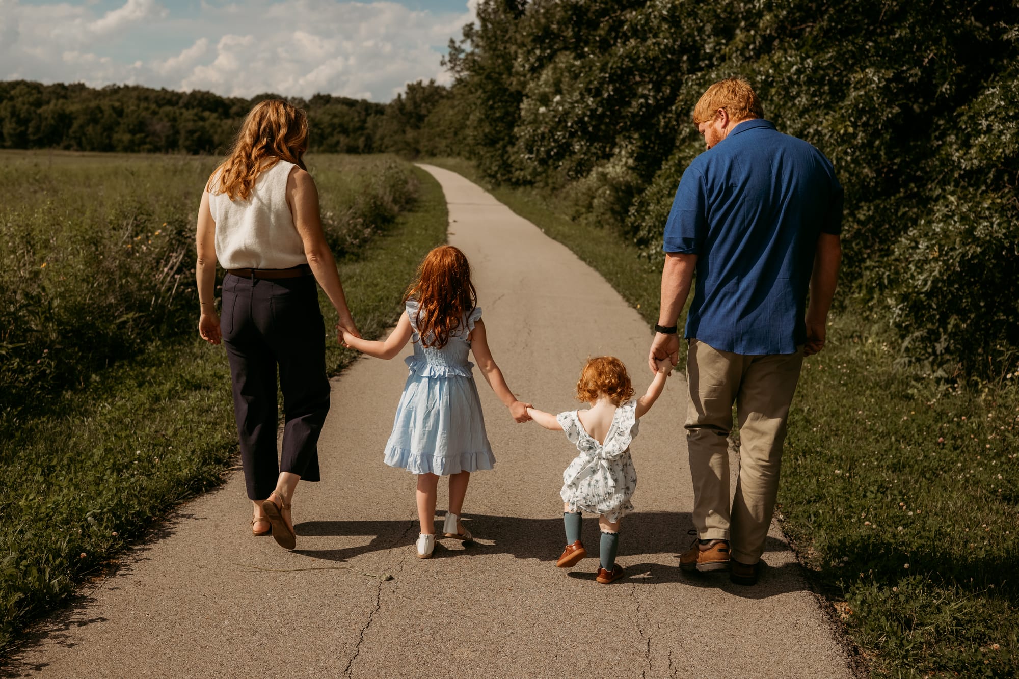 The family walking their two daughters down the lane past the pasture